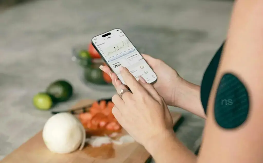 Een vrouw bekijkt haar glucosegegevens op haar telefoon
